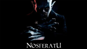 Nosferatu character with pale skin and pointed ears, showcasing a sinister expression and claw-like hands in a dark setting.